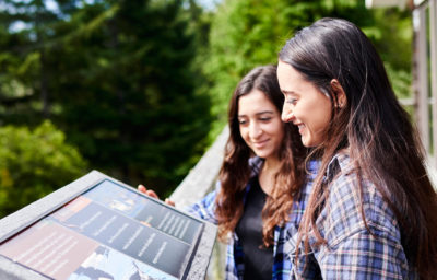 Two women reading signage