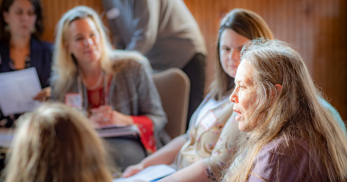 A group of people talking at a conference