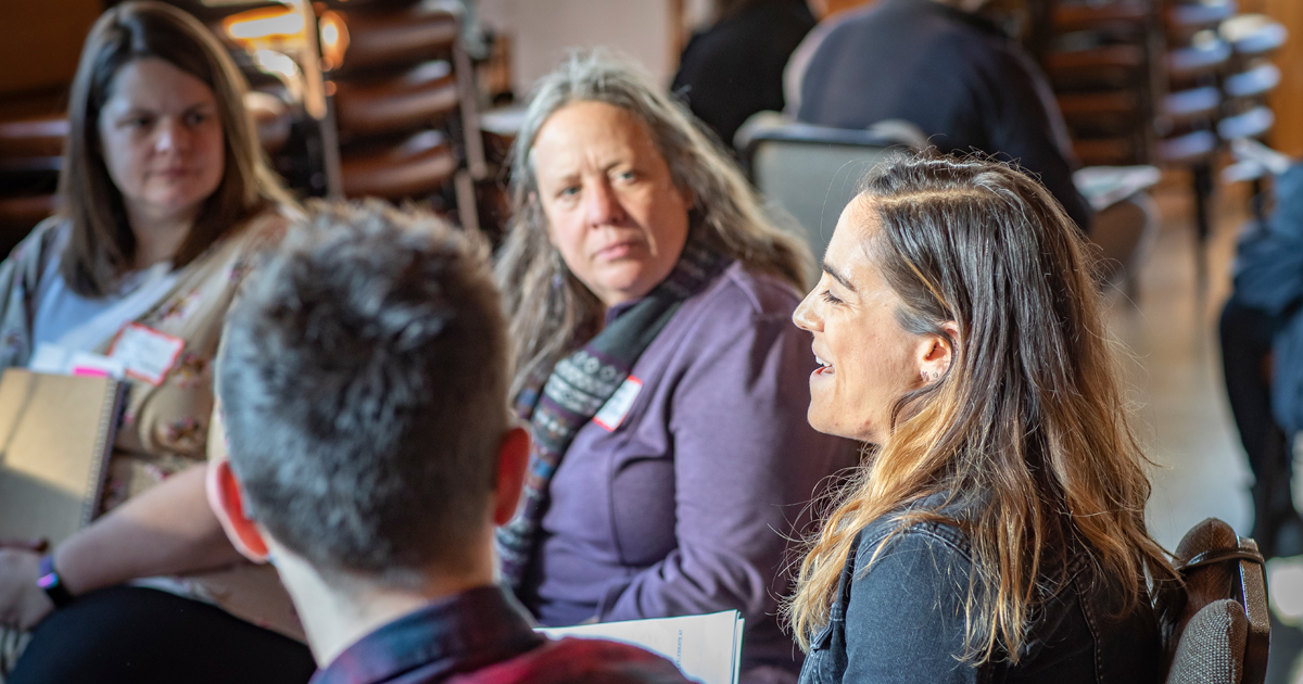 A group of people talking at a conference