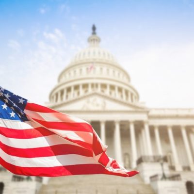 American flag flying in front of Capitol buliding