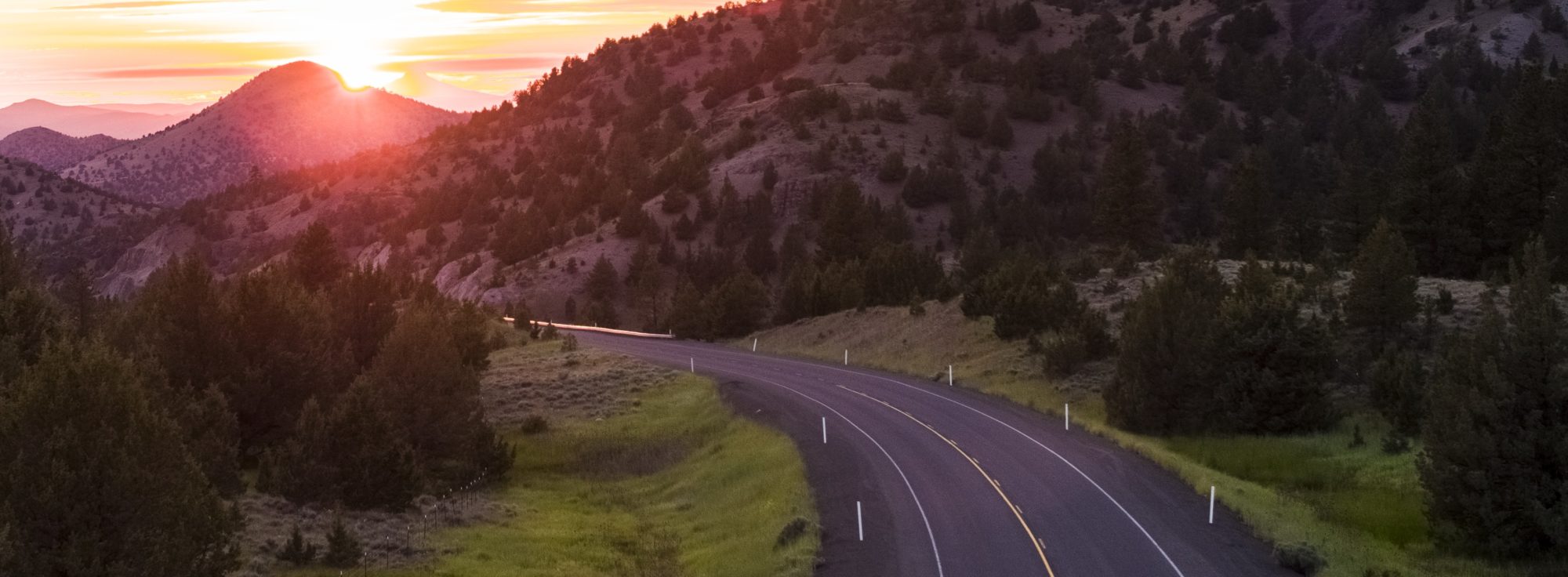 Road in Eastern Oregon with sunset in the distance.