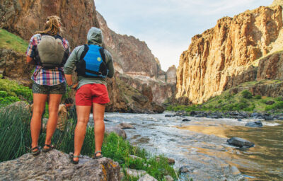 Two women standing on the bank of the Owyhee River.