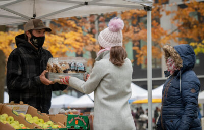 Masked customers purchasing items at the Portland Farmers Market