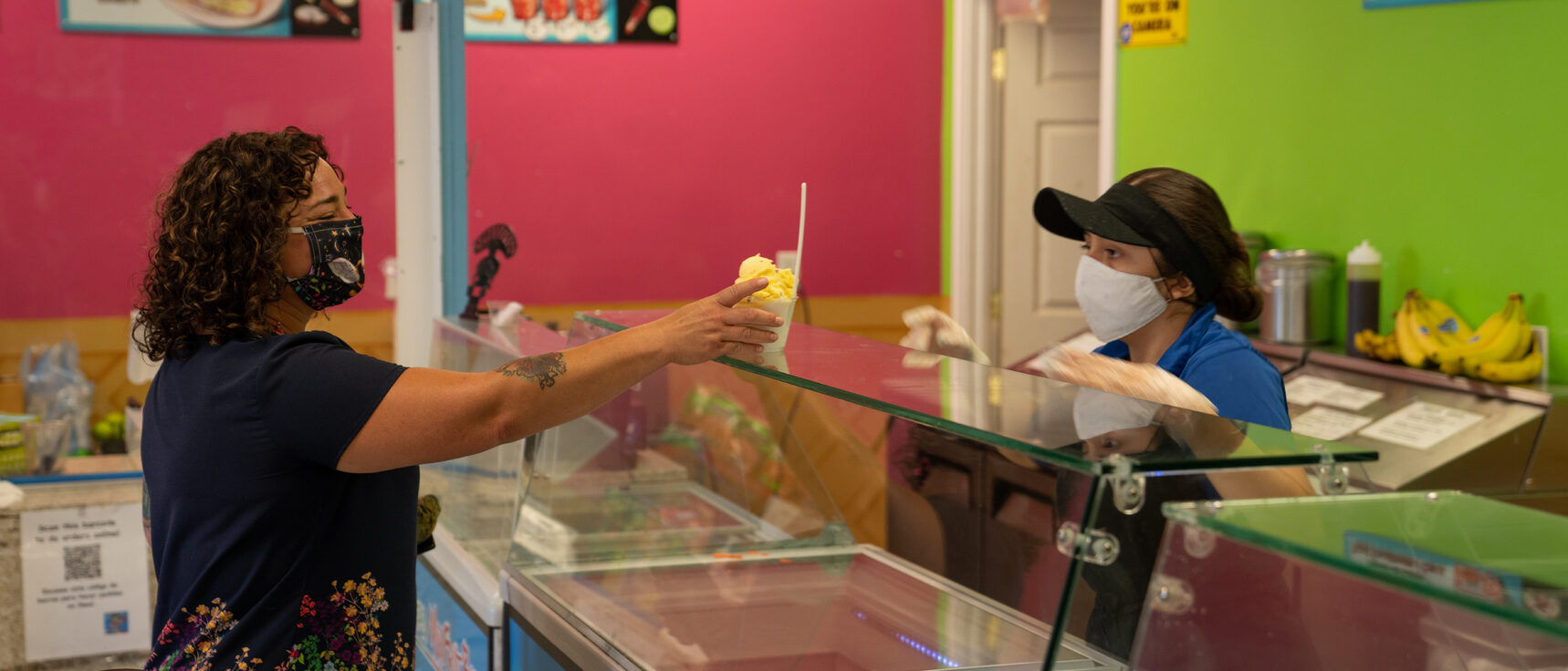 Masked customer purchasing ice cream at shop in Woodburn.