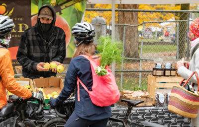 Cyclists shopping for produce at the Portland Farmers Market.