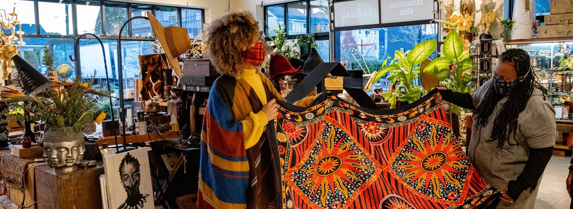 People admiring a tapestry in a shop.