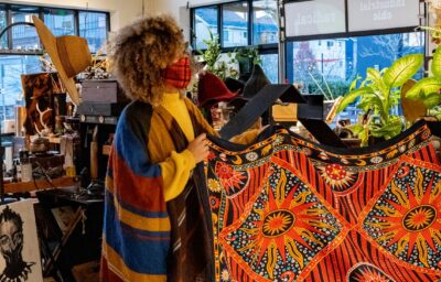 People admiring a tapestry in a shop.