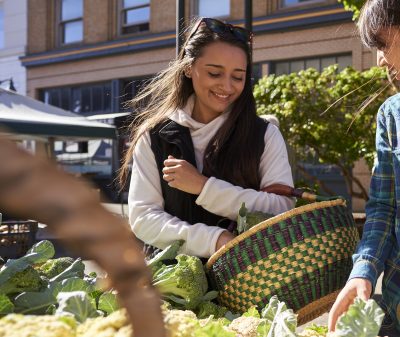 Two women shopping at a Farmers Market in Coos Bay.