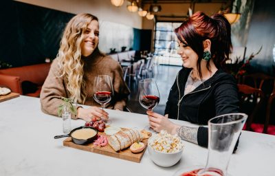 Two women enjoying wine and appetizers at Stem Wine Bar in Portland.