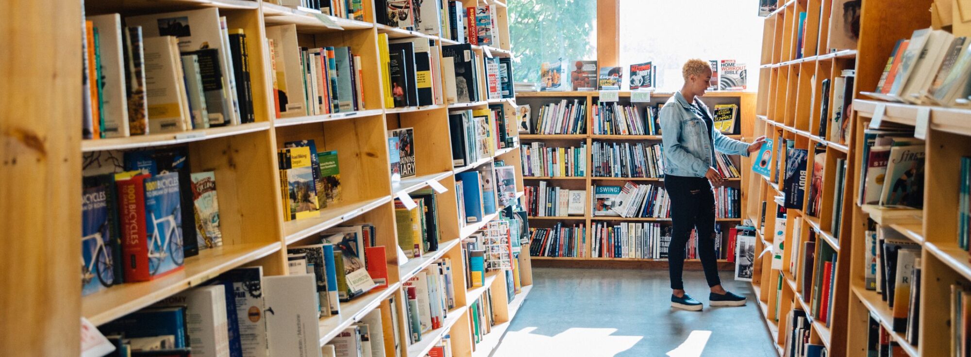 Person perusing books at Powells bookstore.