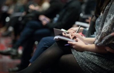 An audience takes notes during a conference training.